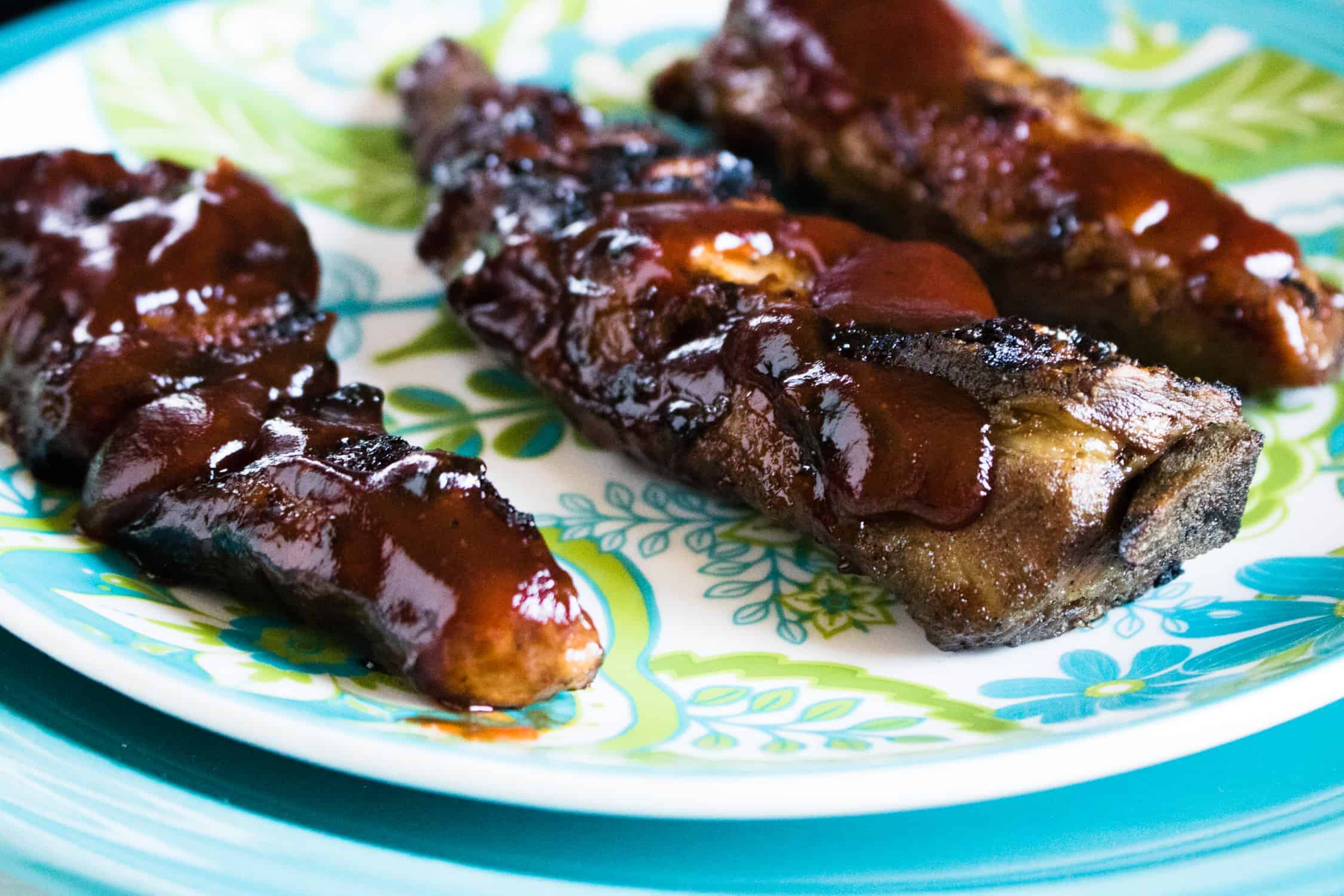 rib tips with bbq sauce on green and blue plate