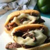 steak and cheese sandwiches on white plate