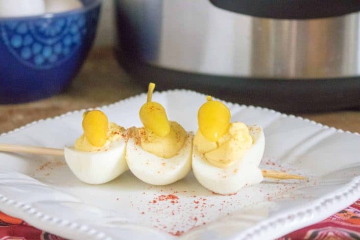 deviled eggs with sweet peppers on top of them on white plate