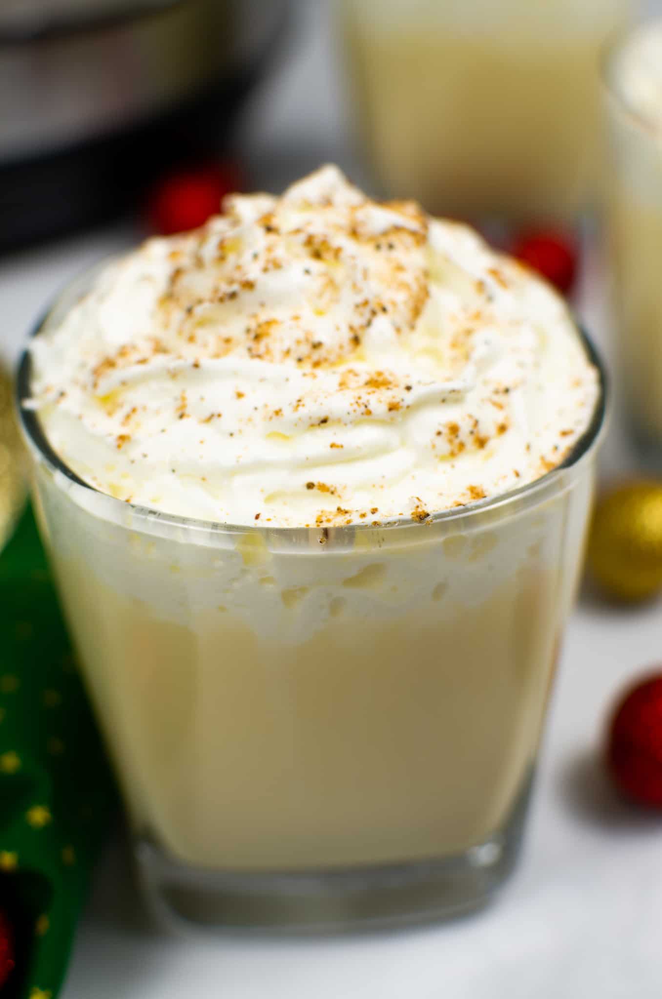 Instant Pot Eggnog in clear glass topped with whipped cream and nutmeg
