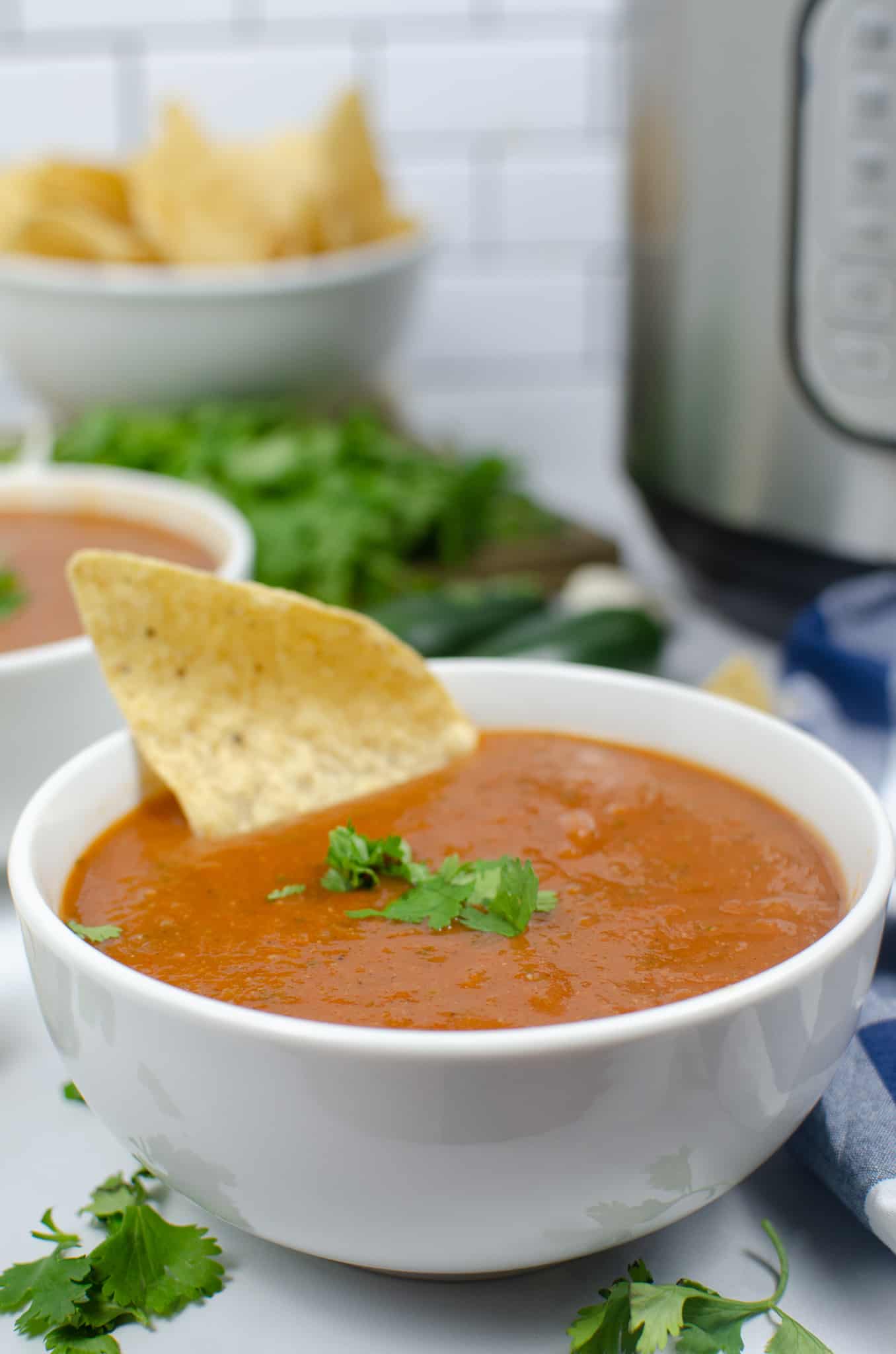 homemade salsa recipe in bowl with bowl of chips in the background