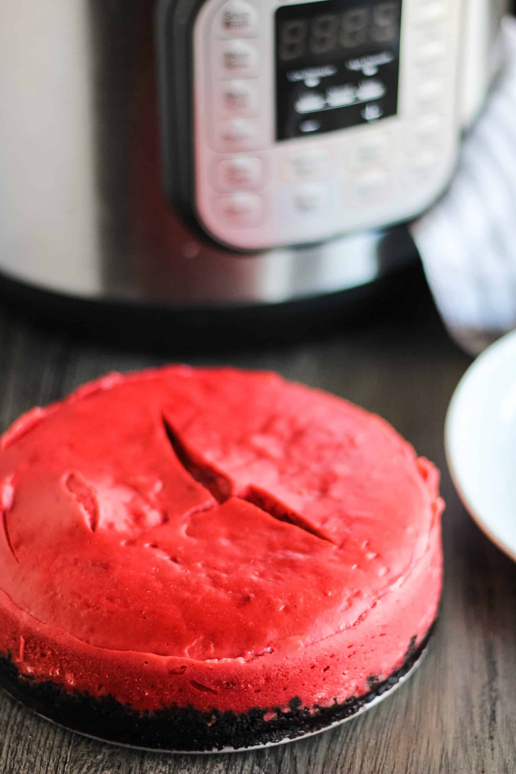 red velvet cheesecake with oreo crust on table with Instant Pot in the background