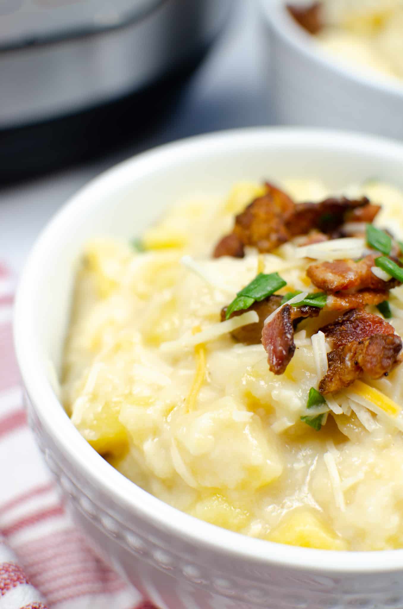 Instant Pot Potato Soup in white bowl with bacon pieces and green onions on top