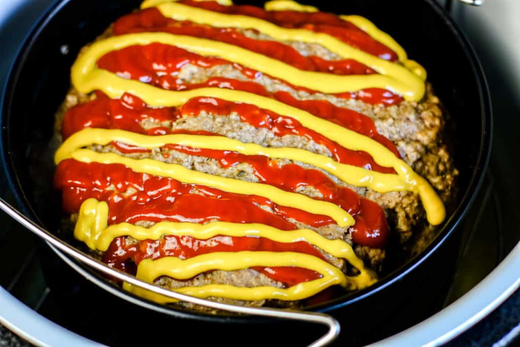 meatloaf in ninja foodi with ketchup and mustard on top
