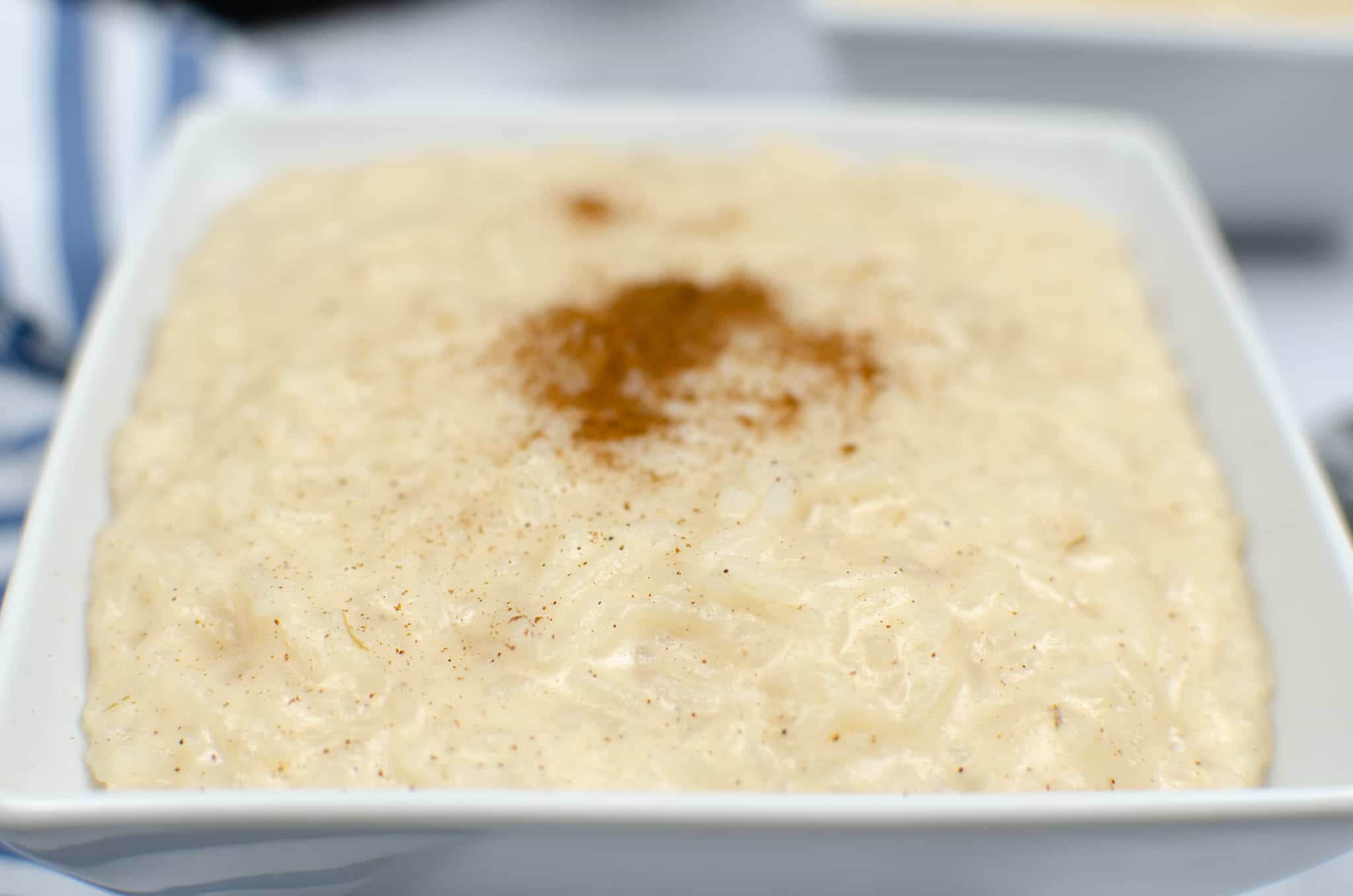 white bowl of old fashioned rice pudding with cinnamon on top