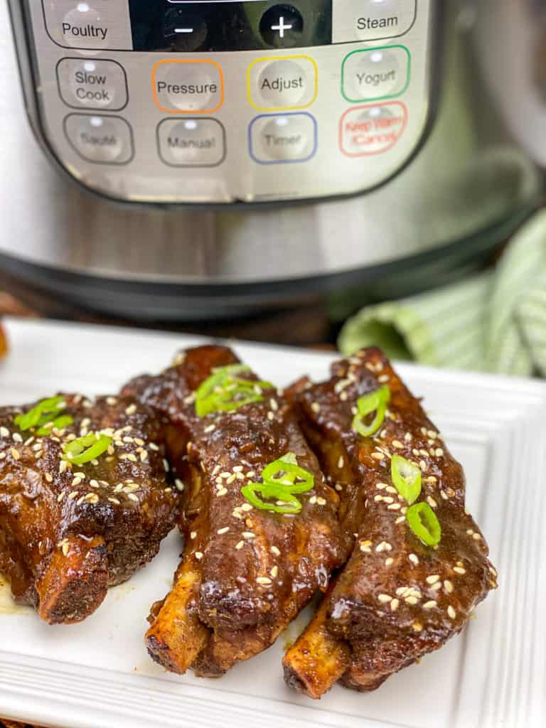 baby back ribs on white platter in front of Instant Pot