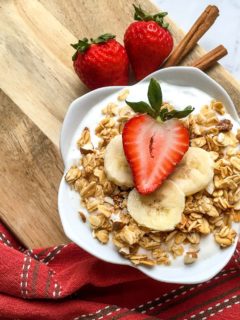 yogurt with granola and fruit in white bowl