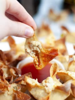 holding crab rangoon dipped in sauce